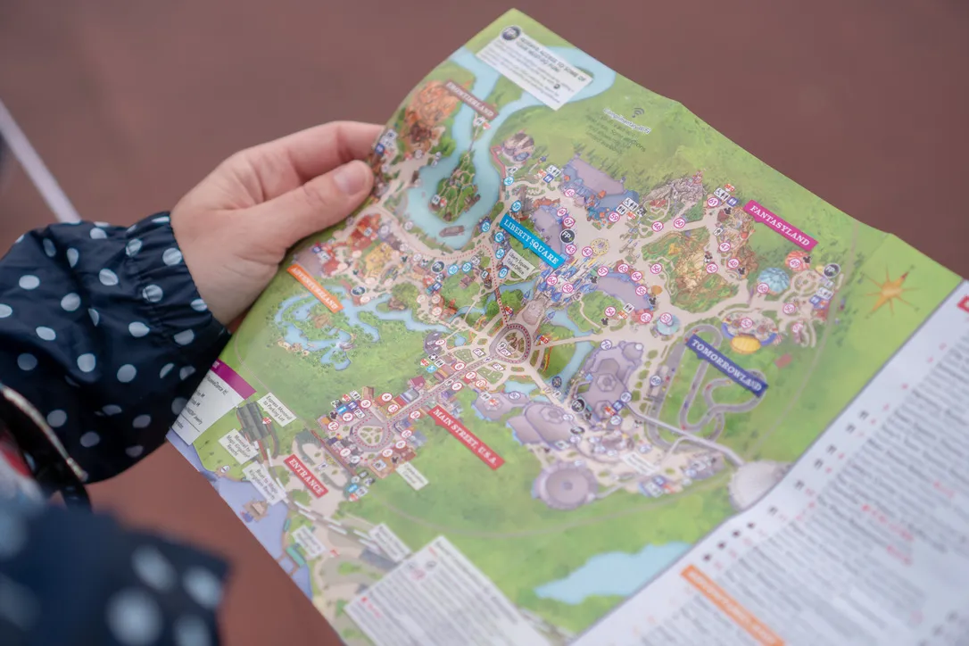 A person holding a map of the Magic Kingdom Theme Park